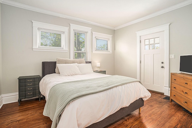 bedroom with multiple windows, dark wood-style floors, ornamental molding, and baseboards