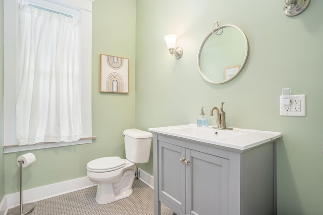bathroom featuring baseboards, toilet, vanity, and tile patterned floors