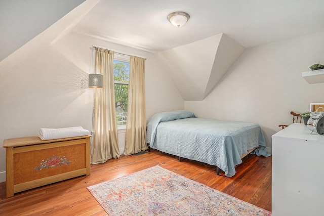 bedroom featuring hardwood / wood-style flooring and vaulted ceiling
