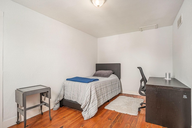 bedroom featuring hardwood / wood-style flooring and baseboards