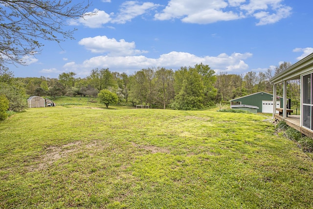 4441 S 38th St, Climax, MI 49034 - view of green lawn featuring an outdoor structure, a detached garage, a shed, and a wooded view