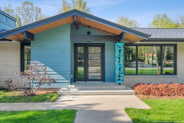 entrance to property featuring brick siding and covered porch