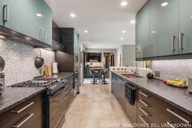 kitchen featuring appliances with stainless steel finishes, a sink, modern cabinets, dark countertops, and recessed lighting