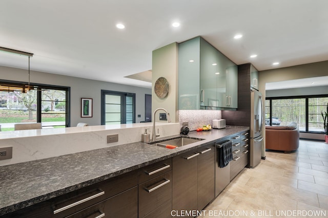 kitchen with a sink, stainless steel appliances, dark stone counters, recessed lighting, and modern cabinets