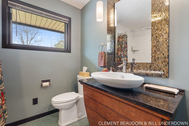full bath with toilet, vanity, and a shower with curtain