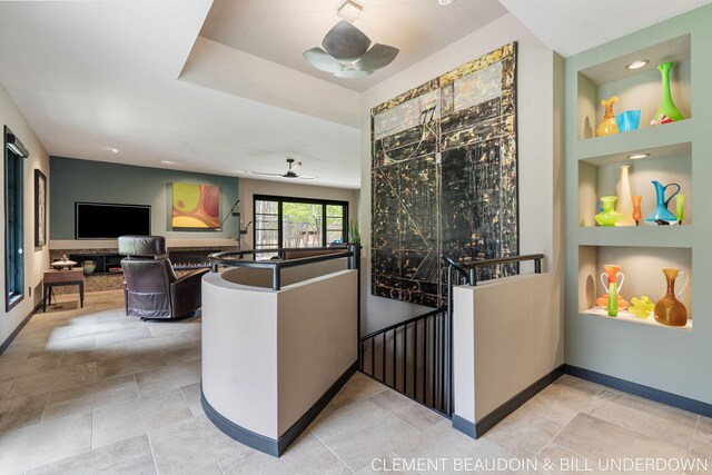 interior space featuring ceiling fan, built in shelves, baseboards, and recessed lighting