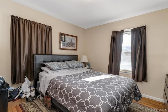 bedroom with wood finished floors and baseboards