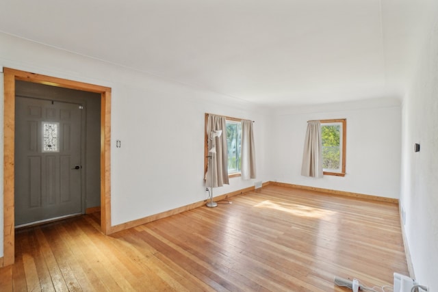 unfurnished room featuring wood-type flooring and baseboards