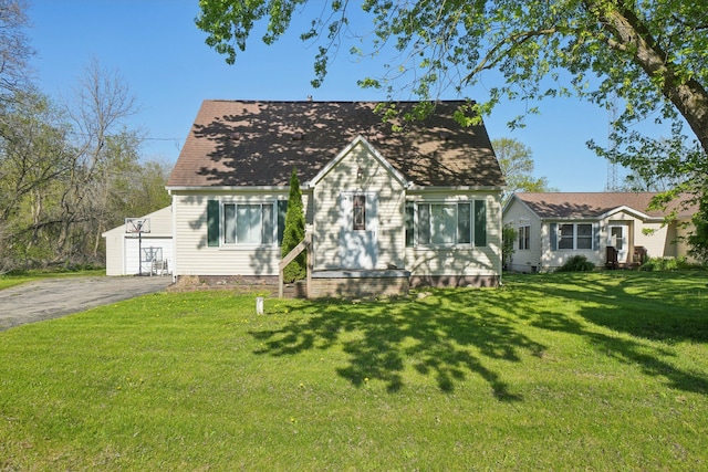 cape cod house with a front lawn and asphalt driveway