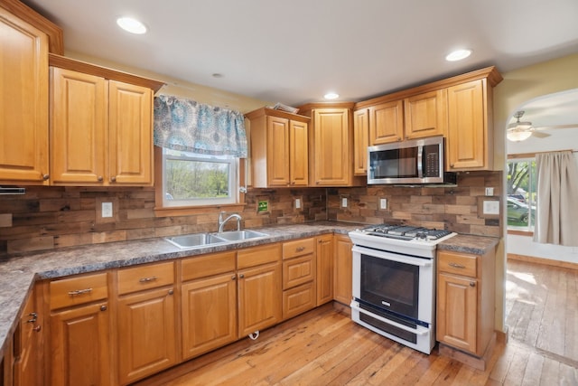 kitchen with stainless steel microwave, white range with gas stovetop, a sink, plenty of natural light, and recessed lighting