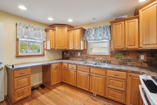 kitchen featuring a sink, stove, light wood-style flooring, tasteful backsplash, and recessed lighting