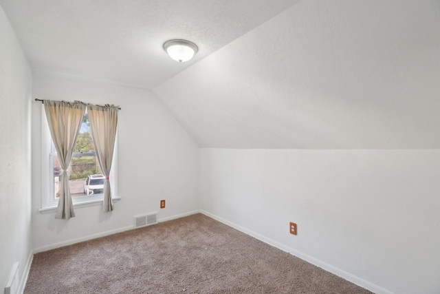 additional living space featuring vaulted ceiling, carpet flooring, and baseboards
