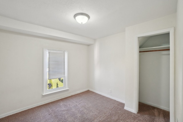 unfurnished bedroom with carpet, a closet, and baseboards