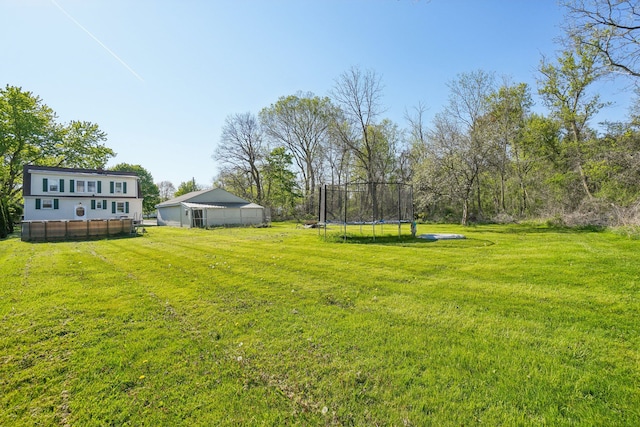 view of grassy yard with a trampoline