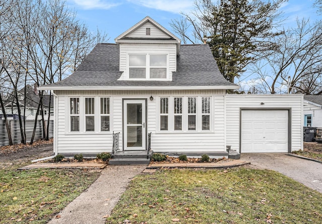 view of front of house with driveway, an attached garage, a front yard, and roof with shingles
