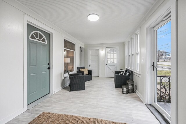 mudroom with healthy amount of natural light, wood finished floors, and baseboards