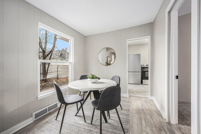 dining room featuring light wood finished floors and baseboards