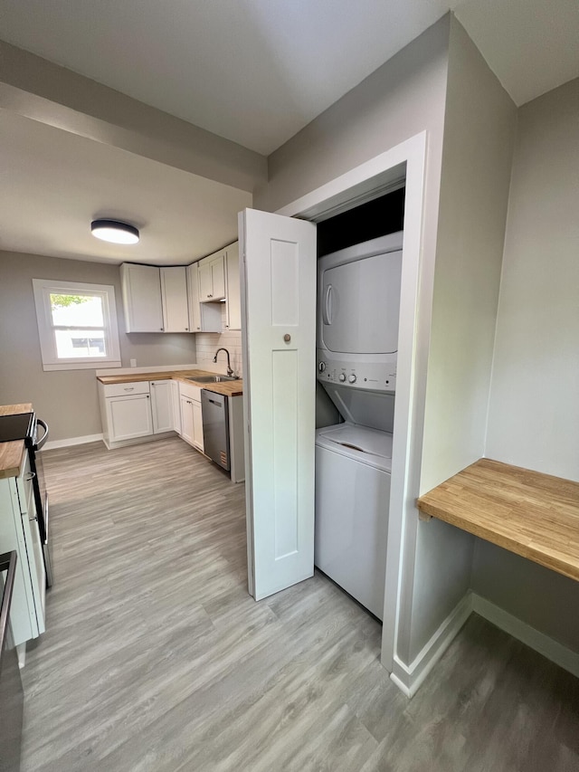 109 S Lake Ave, Spring Lake, MI 49456 - laundry room with stacked washing machine and dryer, light wood-style flooring, and baseboards