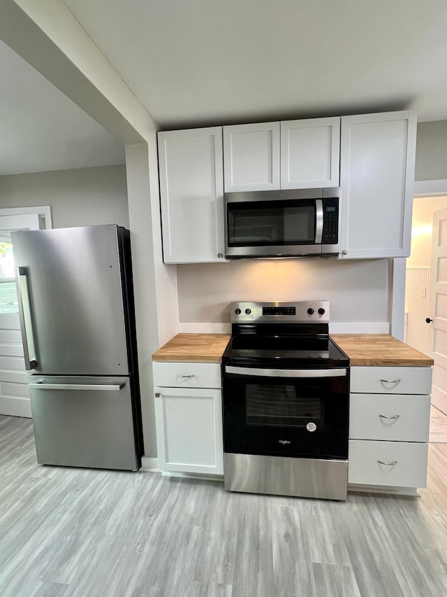 109 S Lake Ave, Spring Lake, MI 49456 - kitchen featuring stainless steel appliances, wooden counters, light wood-style flooring, and white cabinets