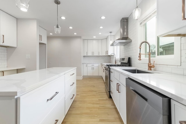 25720 Southwood Dr, Southfield, MI 48075 - kitchen featuring stainless steel appliances, wall chimney range hood, a sink, light wood-style flooring, and healthy amount of natural light