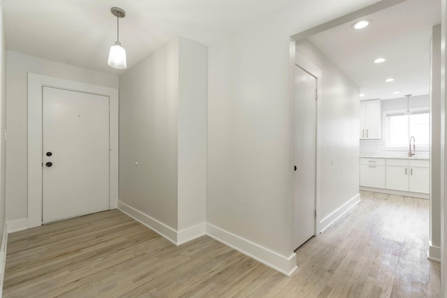 25720 Southwood Dr, Southfield, MI 48075 - hallway with light wood-style flooring, baseboards, recessed lighting, and a sink