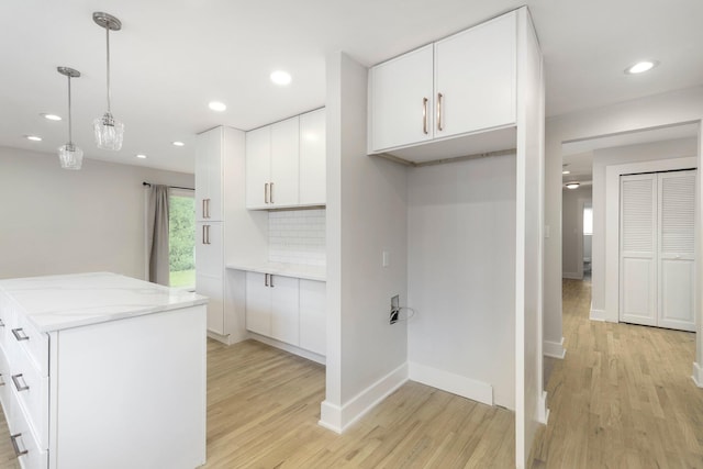 25720 Southwood Dr, Southfield, MI 48075 - kitchen with light wood-style flooring, white cabinetry, baseboards, decorative light fixtures, and a kitchen island