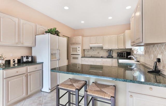 61450 Wedgewood Dr, Washington, MI 48094 - kitchen featuring white appliances, a sink, a peninsula, under cabinet range hood, and tasteful backsplash