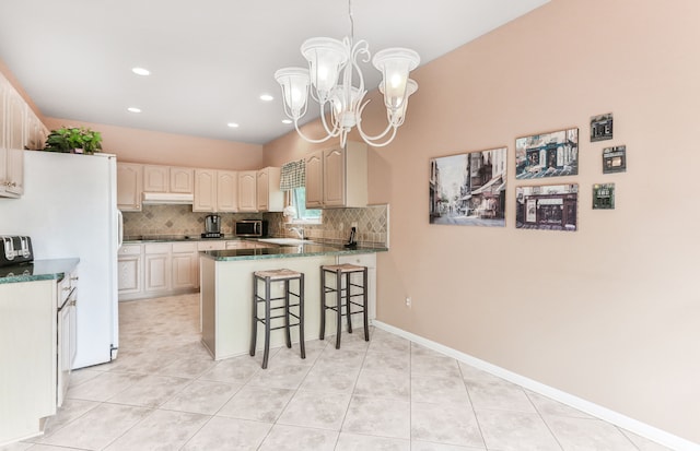 61450 Wedgewood Dr, Washington, MI 48094 - kitchen featuring under cabinet range hood, a peninsula, freestanding refrigerator, backsplash, and a kitchen bar