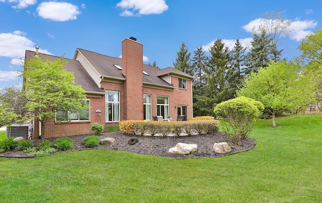 61450 Wedgewood Dr, Washington, MI 48094 - rear view of house with a chimney, brick siding, a yard, and central AC unit