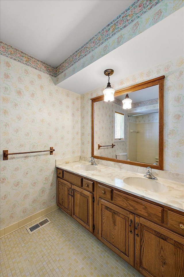 5445 Washakie Trl, Brighton, MI 48116 - full bath with baseboards, double vanity, wallpapered walls, and toilet
