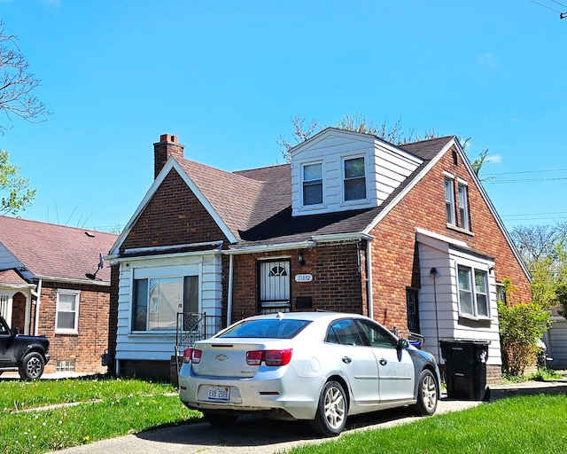 13892 Eastburn St, Detroit, MI 48205 - view of front of home with brick siding, a chimney, and roof with shingles