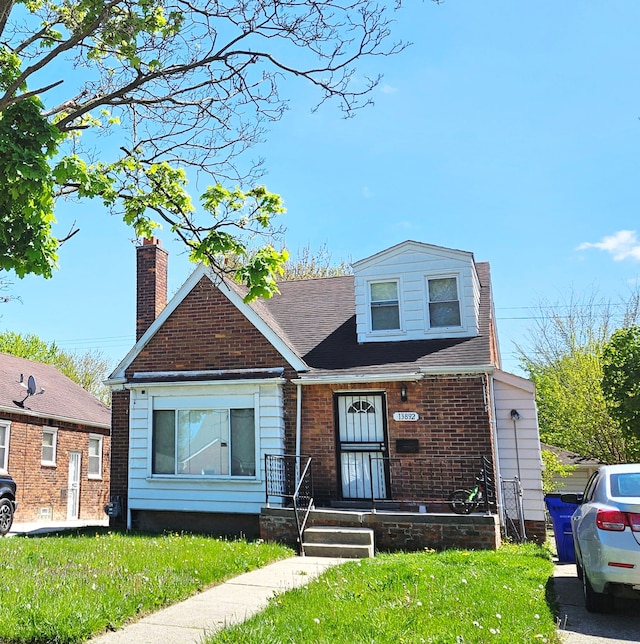 13892 Eastburn St, Detroit, MI 48205 - view of front facade featuring a front lawn, brick siding, and a chimney