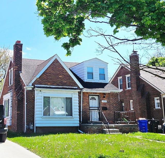 13892 Eastburn St, Detroit, MI 48205 - view of front facade featuring a chimney, brick siding, and a front lawn