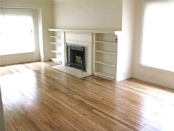 13892 Eastburn St, Detroit, MI 48205 - unfurnished living room featuring wood finished floors and a fireplace