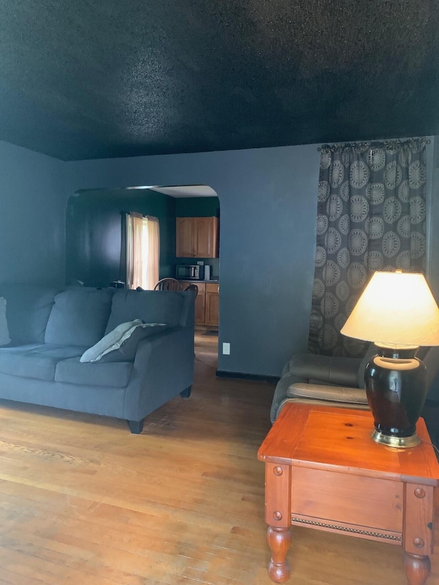 2983 Worden St, Norton Shores, MI 49444 - living room featuring arched walkways, wood finished floors, and a textured ceiling