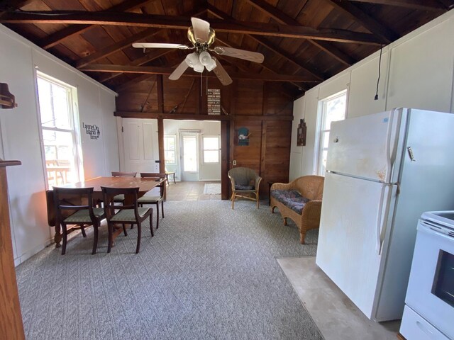 dining space featuring wooden ceiling, carpet, a ceiling fan, beam ceiling, and wooden walls
