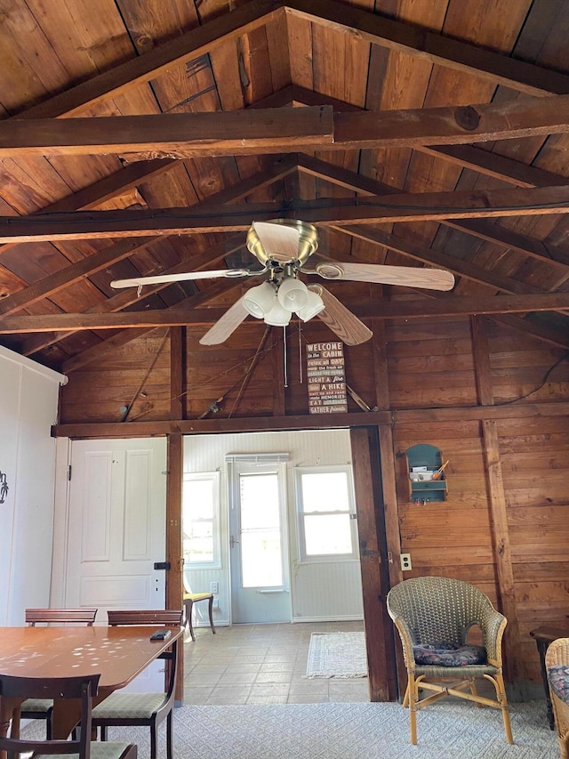 dining area featuring wood ceiling, a ceiling fan, and wood walls