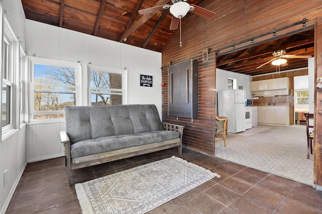 living area with ceiling fan, wooden walls, beamed ceiling, high vaulted ceiling, and wooden ceiling
