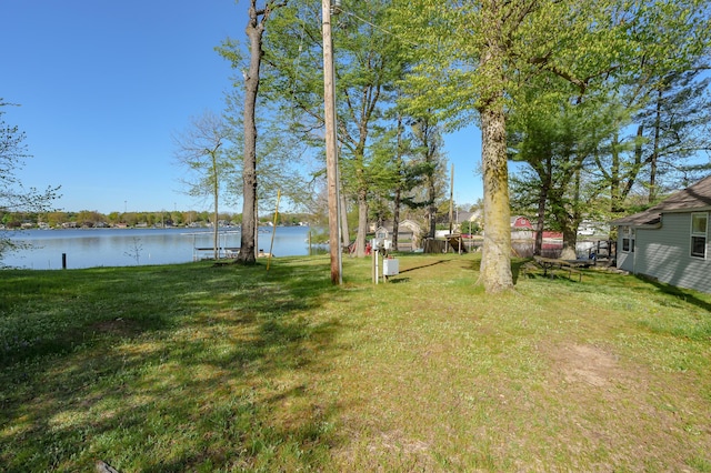 view of green lawn with a water view