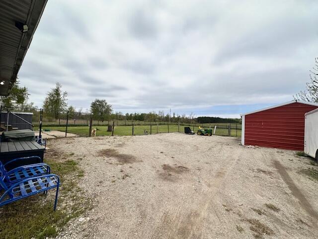 1120 W Montgomery Rd, Camden, MI 49232 - view of yard featuring fence, an outdoor structure, and a view of countryside