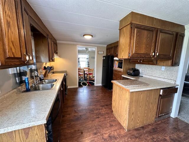 1120 W Montgomery Rd, Camden, MI 49232 - kitchen with black appliances, a sink, dark wood-type flooring, light countertops, and ornamental molding