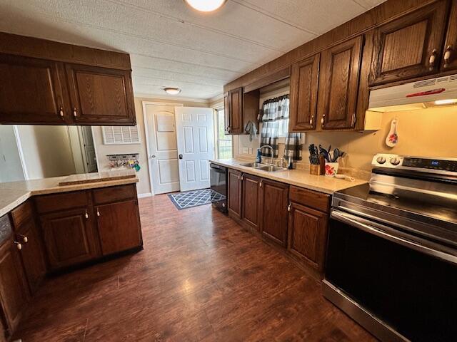 1120 W Montgomery Rd, Camden, MI 49232 - kitchen with stainless steel electric range oven, a sink, under cabinet range hood, dishwasher, and light countertops