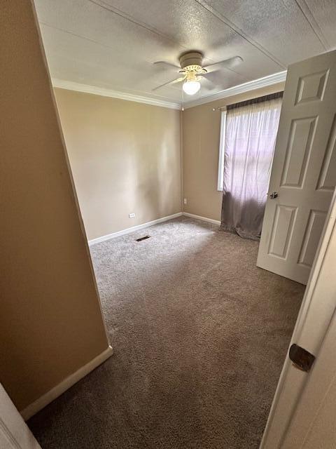 1120 W Montgomery Rd, Camden, MI 49232 - empty room with ornamental molding, carpet floors, a ceiling fan, baseboards, and a textured ceiling