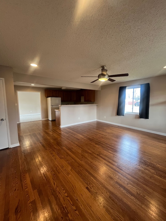 31124 Windsor St, Westland, MI 48185 - unfurnished living room featuring a textured ceiling, dark wood finished floors, ceiling fan, and baseboards