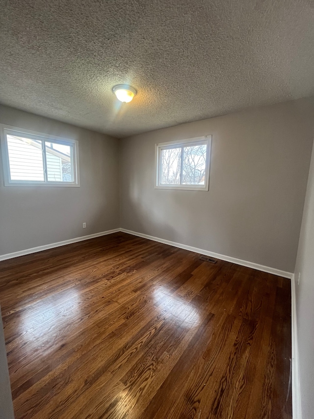 31124 Windsor St, Westland, MI 48185 - unfurnished room with dark wood-style floors, a textured ceiling, healthy amount of natural light, and baseboards