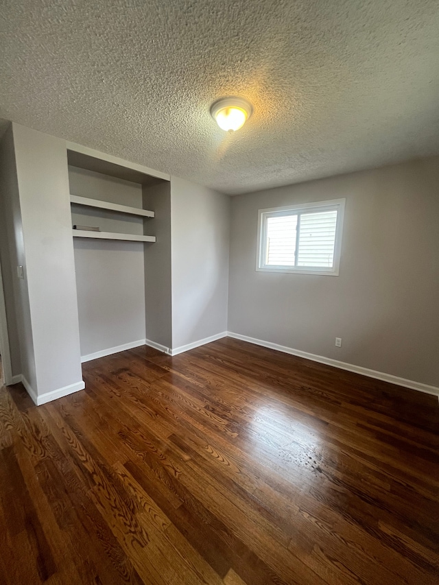 31124 Windsor St, Westland, MI 48185 - unfurnished bedroom with a closet, dark wood-type flooring, a textured ceiling, and baseboards