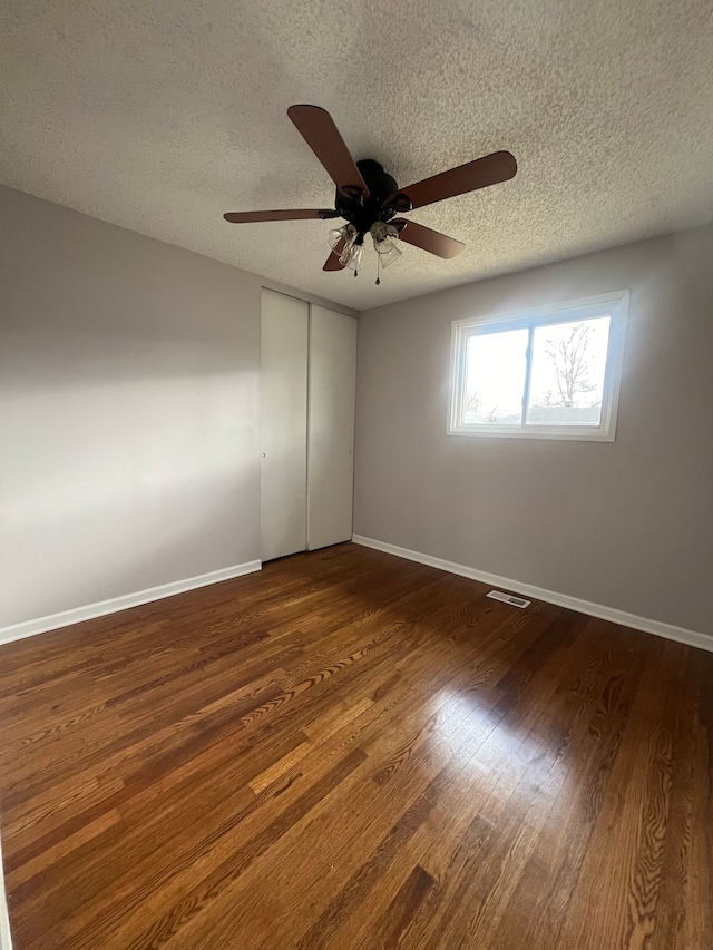 31124 Windsor St, Westland, MI 48185 - empty room featuring a textured ceiling, ceiling fan, dark wood-style flooring, and baseboards