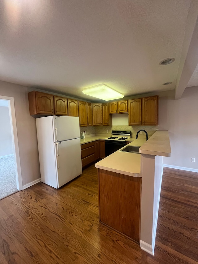31124 Windsor St, Westland, MI 48185 - kitchen with white appliances, a peninsula, dark wood-type flooring, and brown cabinetry