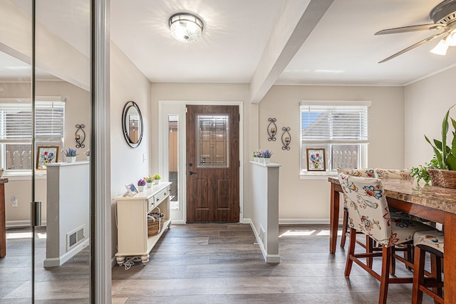 entryway with a ceiling fan, wood finished floors, baseboards, and ornamental molding