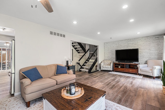 living room with ceiling fan, stairs, wood finished floors, recessed lighting, and baseboards